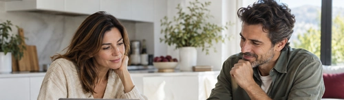 Hombre y mujer hablando con calma en la cocina sobre el reparto de la casa hipotecada tras su divorcio